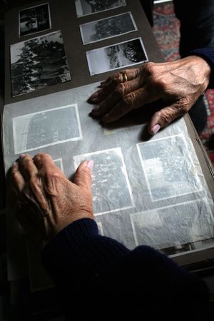 An old woman's hands on an old photo album