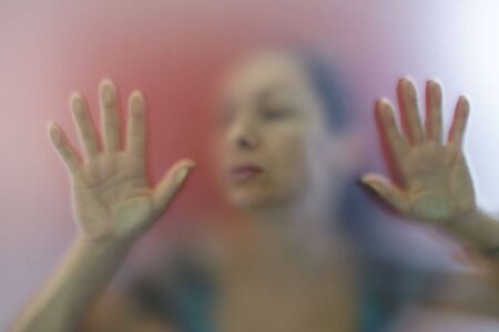 Woman pushing a glass window to openの写真素材
