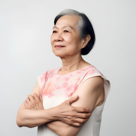 Portrait of asian senior woman with arm crossed on gray backgroundの素材