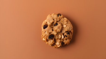 Chocolate chip cookie with raisins on a brown background.の素材