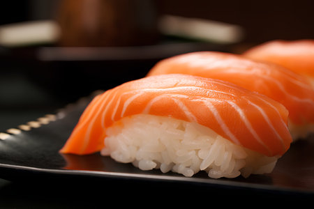 Close up of salmon nigiri sushi served on a black plate.の素材