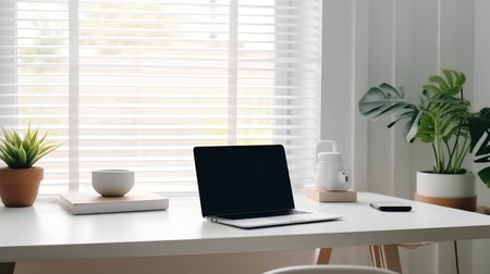 Workplace with laptop, coffee cup and plant on table in officeの素材