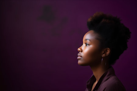 Beautiful young african american woman looking away on purple backgroundの素材