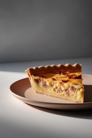 Slice of homemade pie with ham, cheese and apples on a plateの素材