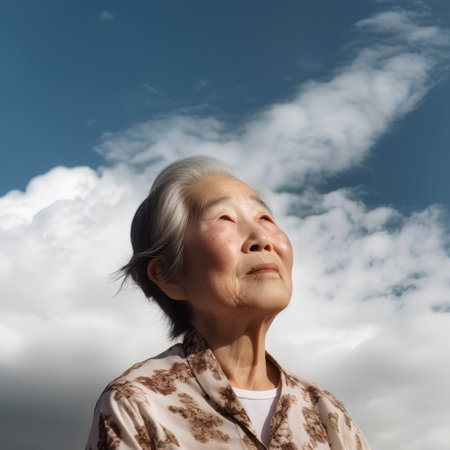 Elderly asian woman with blue sky and cloud background.の素材