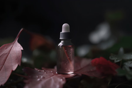 Essential oil in a glass bottle on a dark background. Selective focus.の素材