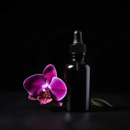 Bottle of essential oil with orchid flower on black background.の素材
