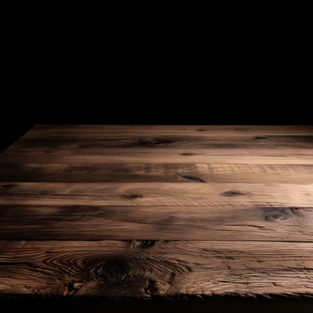 Wooden table in front of a black background. Toned.の素材