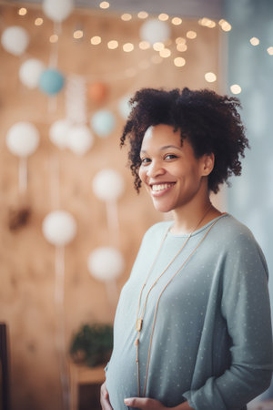 smiling african american pregnant woman looking at camera at homeの素材