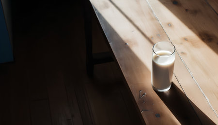 Glass of milk on the table in the morning light. Selective focus.の素材
