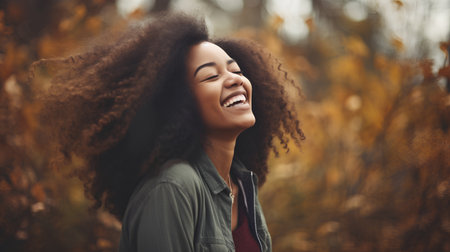 Beautiful young african american woman with afro hairstyle in autumn parkの素材