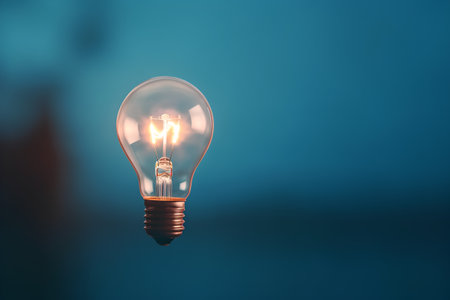Incandescent light bulb on blue background. 3D rendering.の素材