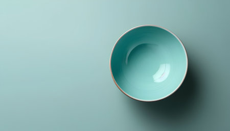 Empty blue bowl on turquoise background, top view, copy spaceの素材