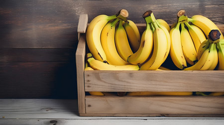 Bunch of bananas in a wooden box on a rustic wooden backgroundの素材