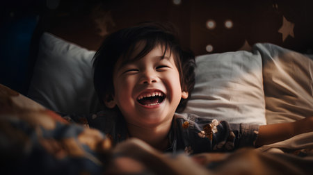 Happy asian little girl laughing in bed at home. Happy childhood concept.の素材