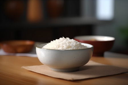 Rice in a bowl on a wooden table in a kitchen.の素材