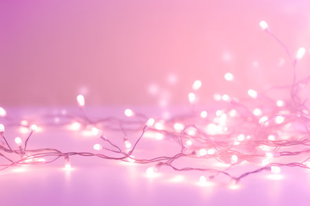 Christmas lights on pink background. Glowing garland. Christmas greeting card.の素材