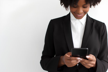 Young african american businesswoman using mobile phone on white backgroundの素材