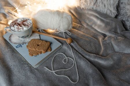 Knitting and reading in bed with hot chocolate and cookies, cozy winter concept, top viewの写真素材