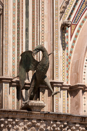 Statue of an eagle on the facade of The Cathedral of Orvieto, one of the greatest artistic achievements of the Italian late Middle Ages with our Gothic-style facadeの写真素材