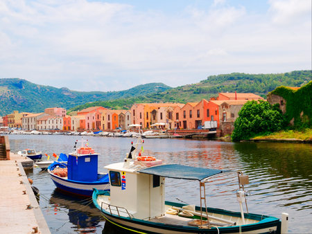 iew of fishing boats and beautiful colorful houses in the city of Bosa. province of Oristano, Sardinia, Italyの写真素材