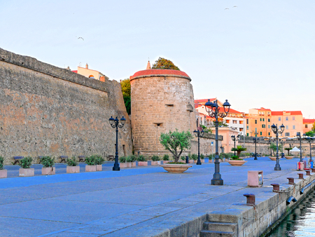 View from the promenade to the city and the city walls in Alghero, Sardinia.