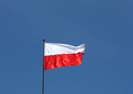 Polish flag over blue sky の写真素材