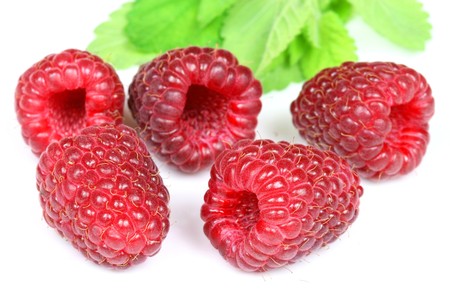 Fresh raspberries with a lemon balm leaf. Closeup of fruits on a white background.