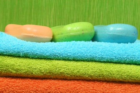 Bath and spa accessories - three colorful towels and soapの写真素材