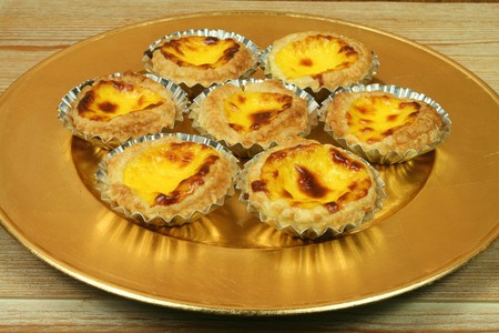 Traditional portuguese egg tarts - pastries pasteis de nata on golden plate