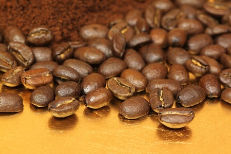  Whole roasted coffee arabic beans and ground on golden plateの写真素材