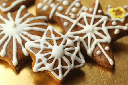 Gingerbread stars with icing decoration on golden plate