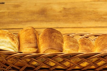 Basked with fresh baked butter rolls on wooden background