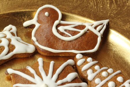 Gingerbread cookies - duck decorated with icing on golden plateの写真素材