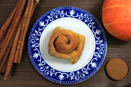 Halloween autumn pumpkin yeast bun with cinnamon on decorative plateの写真素材