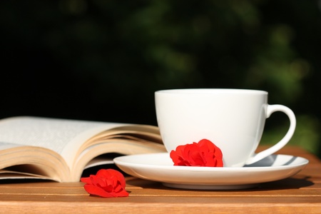 Relax in the garden - coffee, book and red begonia flowersの写真素材