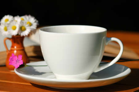 Coffee and beautiful wild flowers: pink and daisies on the table