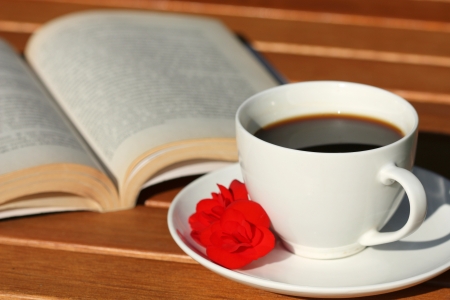 Cup of coffee and book in natural garden light Cup of coffee and book in natural garden light