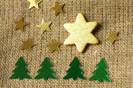 Christmas decoration - golden stars and Christmas trees on flaxの写真素材
