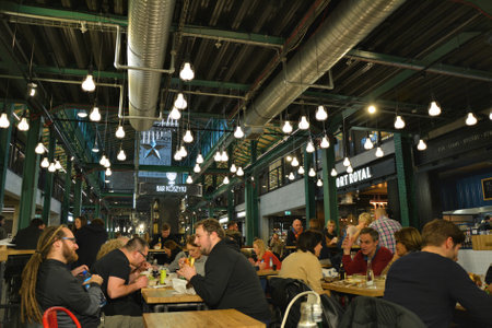 WARSAW, POLAND - NOVEMBER 25, 2016: People meet and eat fancy food at Hala Koszyki in Poland. Hala Koszyki is a new trendy food court with choice of various cuisines in Warsawのeditorial素材