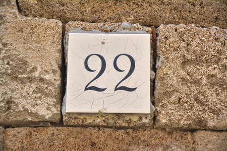 Tile with the number 22 on the old stone wallの写真素材