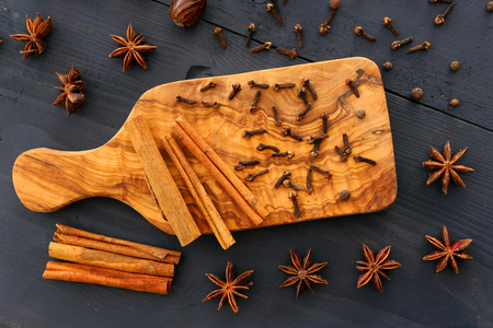 Christmas spices on wooden background. Food ingredients: star anise, cloves, nutmeg and cinnamon sticks, allspice.の写真素材