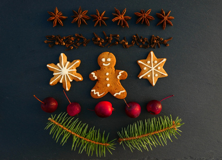 Christmas decoration background with gingerbread cookies. Spruce branches, spices and apples on...