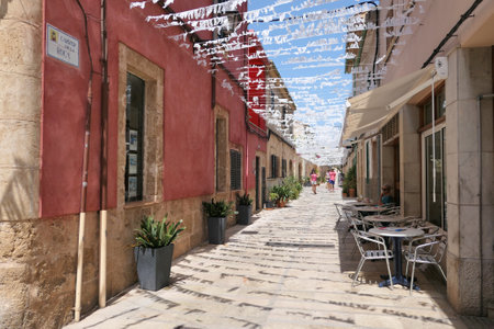 ALCUDIA, SPAIN -  AUGUST 10, 2019: Narrow alley Carrer De La Roca in seaside Alcudia old town, Mallorca island, Spain.のeditorial素材