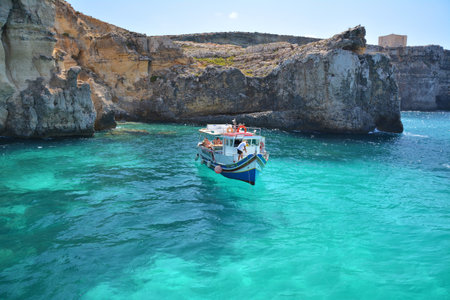 Comino, Malta - August 24, 2020 - Tourist boat at Crystal lagoon bay at Comino island, Malta.のeditorial素材