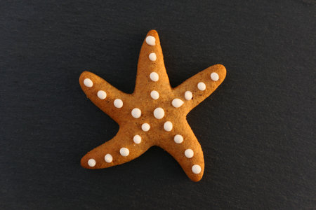 Starfish shape gingerbread cookie on black backgroundの写真素材