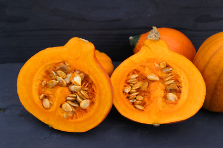 Pumpkins in the kitchen. Cut orange Hokkaido pumpkin with seeds.の素材 [FY310198642924]