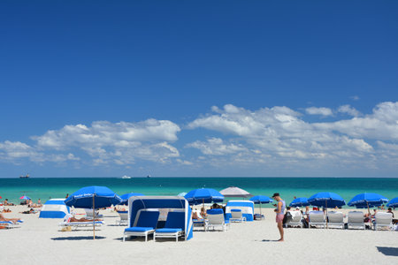 Miami Beach, USA - March 18, 2017: Tourists on beach sunbeds and umbrellas in South Beach, Miami Beach by Atlantic Ocean.のeditorial素材