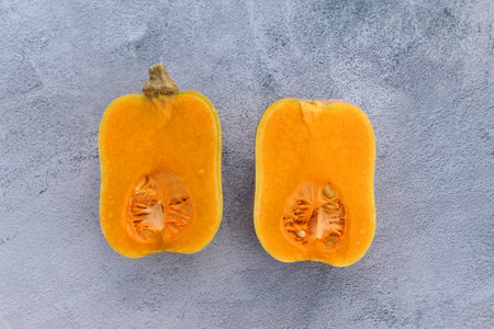 Butternut squash cut in half on gray background.の写真素材