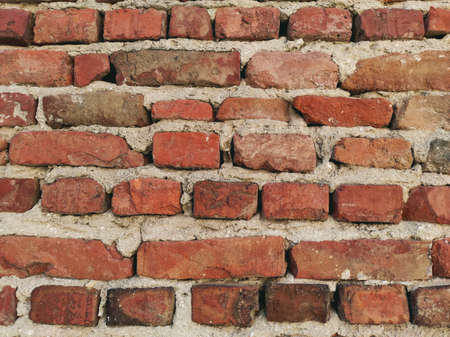 A wall of old bricks that have fallen into disrepair.